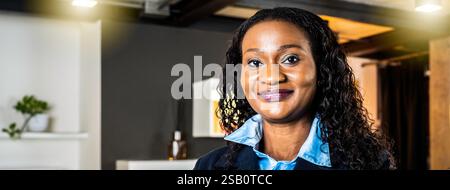 Horizontales Banner oder Kopfzeile mit afrikanischer Geschäftsfrau, die in einem modernen Büro arbeitet, mit dem multiethnischen Team dahinter - Konzept der Führung und t Stockfoto