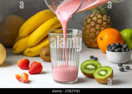 Frischer Smoothie in Glas auf weißen Küchentisch Stockfoto