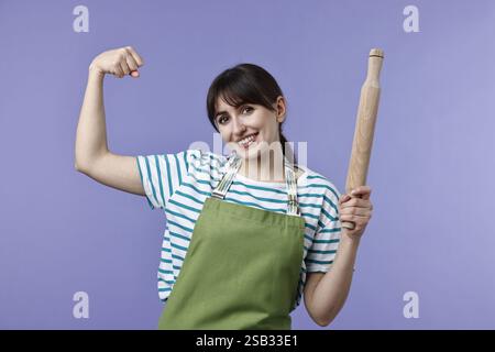 Eine Frau mit einem Pin, der Stärke auf violettem Hintergrund zeigt Stockfoto
