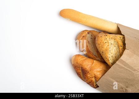 Verschiedene frisch gebackene Brote in brauner Papiertüte auf weißem Hintergrund. Stockfoto