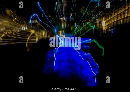 Eine Langzeitaufnahme eines Schwimmbades bei Nacht erfasst wirbelnde abstrakte Lichtspuren vor einem dunklen schwarzen Nachthimmel Stockfoto