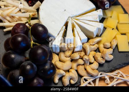 Teller mit Vorspeisen - Käse, Brie, Trauben und Nüsse - Blick von oben Stockfoto