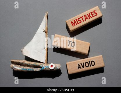 Fehler, um Symbol zu vermeiden. Holzblöcke mit Wortfehlern, die man vermeiden sollte. Schöner grauer Hintergrund mit Boot. Geschäfte und Fehler zur Vermeidung von Konzepten. Cop Stockfoto