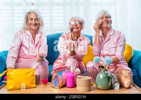 Schöne ältere Frauen, die zu Hause lustige Pyjama-Party haben - Gruppe von fröhlichen älteren weiblichen Freunden, die sich schminken und Spaß haben, Konzepte über alte P Stockfoto