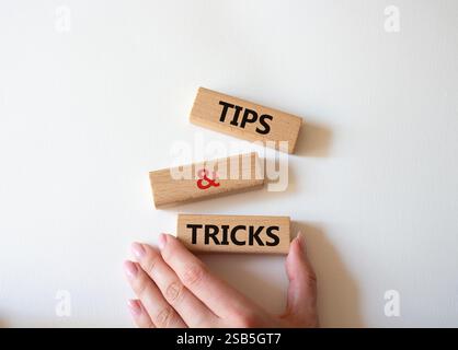 Symbol für Tipps und Tricks. Holzblöcke mit Worten Tipps und Tricks. Schöner weißer Hintergrund. Geschäftsmann Hand. Geschäftskonzept und Tipps und Tricks. Stockfoto