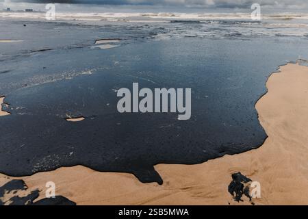 Öl an der Küste nach einem Tankerunglück. Treibstoffleck und verschmutzter Strand Stockfoto