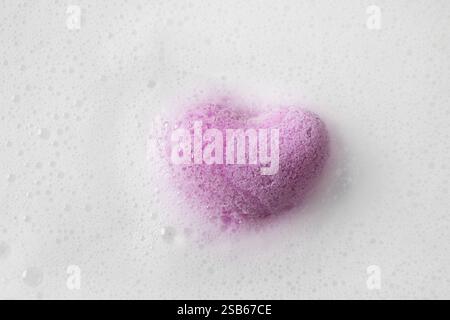 Valentinstag herzförmiges Badesalz in weißem Schaum als Hintergrund. Blick von oben. Love-Konzept. Romantisches Day Spa. Stockfoto