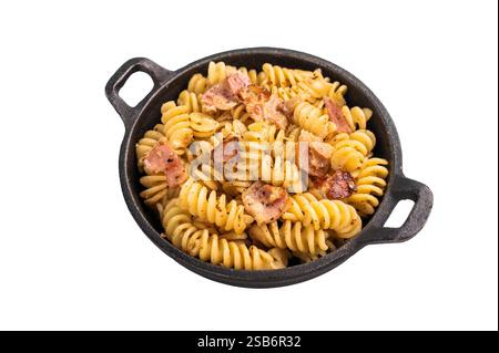 Fusilli köstliche Carbonara-Pasta mit knusprigen Speckstückchen und frischen Kräutern in einer Pfanne isoliert auf weißem Hintergrund. Stockfoto