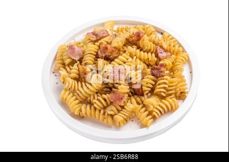 Fusilli Carbonara Nudeln mit knusprigen Speckstückchen und Parmesan auf einem Teller isoliert auf weißem Hintergrund. Stockfoto