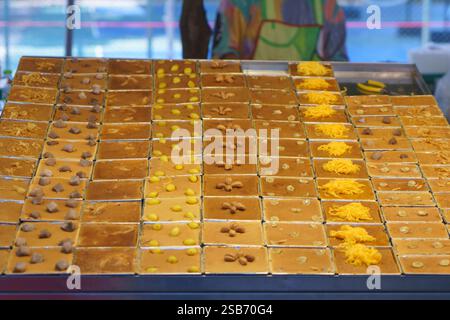 Präsentation traditioneller thailändischer Pudding-Desserts, bekannt als „Khanom Mo Kaeng“, ordentlich in quadratischen Tabletts mit verschiedenen Belägen, einschließlich Ginkgo-Nüssen, Stockfoto