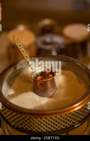 Türkischer Sandkaffee. Zubereitung von türkischem Kaffee im Sand. Türkische Methode der Kaffeezubereitung. Östlicher Kaffee. Stockfoto