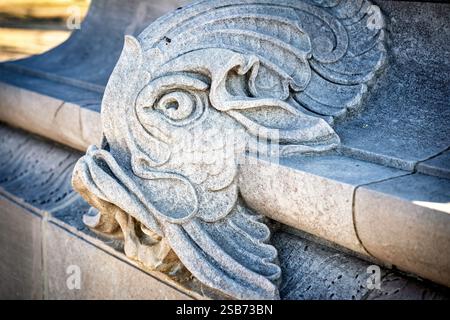 WASHINGTON DC – das John Paul Jones Memorial verfügt über in Stein gehauene Fischköpfe, die als dekorative Wasserauslässe am Sockel des Sockels dienen. Die Bronzestatue, die 1912 vom Bildhauer Charles Henry Niehaus und dem Architekten Thomas Hastings geschaffen wurde, zeigt den Marineheld des Unabhängigkeitskrieges in Offizierskleidung aus der Zeit. Der Marmor-Pylon enthält militärische Symbole und ein Relief, das Jones zeigt, wie er die erste amerikanische Flagge auf einem US-Kriegsschiff hisst, neben seiner berühmten Erklärung „Kapitulation? Ich habe noch nicht angefangen zu kämpfen!" Stockfoto
