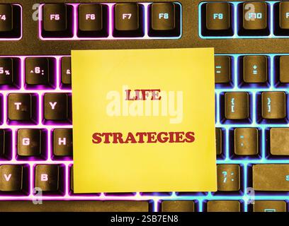 Das Konzept von Business und Entwicklung. Die konzeptuelle Inschrift von LEBENSSTRATEGIEN auf einem gelben Aufkleber, der auf der Tastatur liegt. Stockfoto