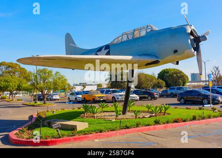 Los Angeles, Kalifornien - 6. Januar 2025: Skulptur eines Militärflugzeugs auf einem Sockel in einem landschaftlich gestalteten Parkplatz, die die Luftfahrt-Hi zeigt Stockfoto