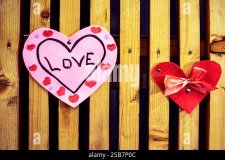 Zwei rote Herzen mit einer Inschrift auf hölzernem Hintergrund. valentinstag Stockfoto
