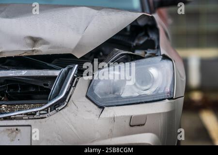 Beschädigtes silbernes Auto auf dem Parkplatz mit Frontalkollision Stockfoto