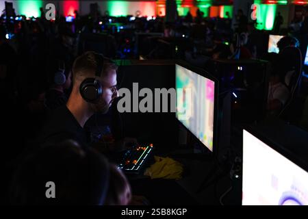 Spieler, der an einem Spielwettbewerb teilnimmt, vor einem Computermonitor sitzt und Videospiele spielt. Stockfoto