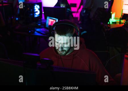 Spieler, der an einem Spielwettbewerb teilnimmt, vor einem Computermonitor sitzt und Videospiele spielt. Stockfoto