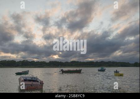 Farbenfroher Himmel bei Sonnenuntergang in Morbihan mit dem Golf und Booten im Vordergrund Stockfoto