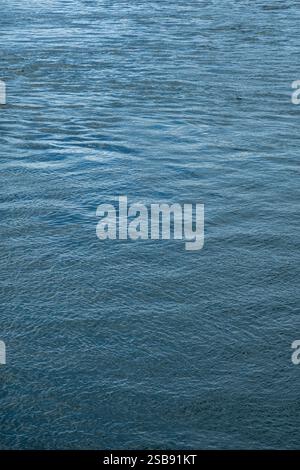 Abstrakte azurblaue Wasseroberfläche mit milden Wellen, vertikales Bild Stockfoto