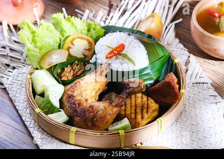 Nasi Ayam Bakar, gebratenes Huhn mit Tempeh, Chilipaste und Gemüse. Indonesisches Essen Stockfoto