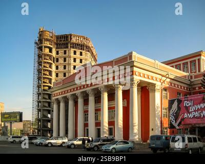 Ein großes Gebäude mit einem Schild auf dem steht "RUBI". Das Gebäude ist von Autos und ein paar Leuten umgeben Stockfoto