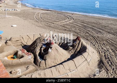Foto von der wunderschönen Strandfront in der spanischen Stadt Benalmadena, die die Strandfront und eine riesige Sandburg am Strand an einem sonnigen Tag zeigt Stockfoto