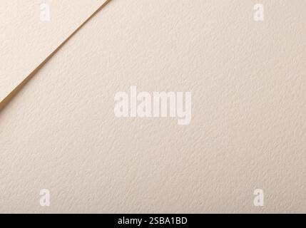 Ein beigefarbener Papierhintergrund mit strukturierter Oberfläche, in sanften Tönen und einer neutralen, natürlichen Ästhetik. Seine minimalistische Komposition betont einfach Stockfoto
