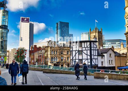 Eine Stadtlandschaft mit einer Mischung aus moderner und historischer Architektur in Manchester, England. Ein Gebäude im Tudor-Stil steht in der Nähe moderner Hochhäuser. Stockfoto