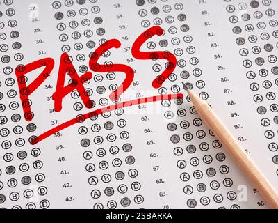 Das Wort Pass steht auf einem Blatt Prüfungspapier mit Bleistift. Erziehungserfolg, gute Noten und Bewertungskonzept. Stockfoto