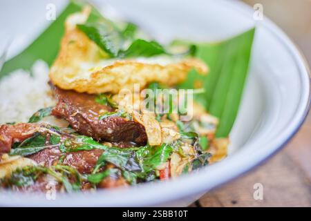 Pad Kra Pao. Heiliges Basilikum-Rinderbraten mit Spiegelei im thailändischen Stil. Thailändische Speisekarte Stockfoto
