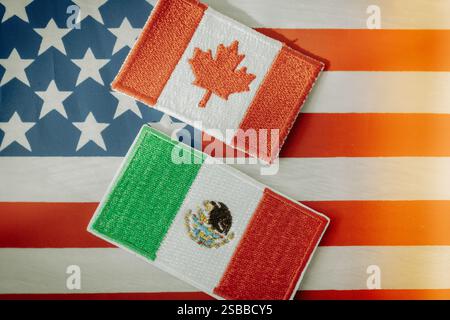 Symbole von Kanada und Mexiko vor dem Hintergrund der amerikanischen Flagge. Wirtschafts- und Geschäftskonzept. Gegenseitige Handelsbeziehungen des nordamerikanischen CUN Stockfoto
