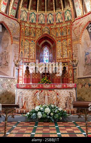 St. Peter's Church in Hascombe Village in Surrey Hills AONB, England, Großbritannien. Blick von innen auf den Altar und die kunstvoll verzierte Heiligtümer Stockfoto