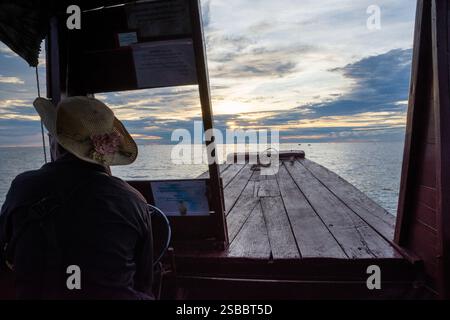 Kompong Khleang, Kambodscha - 25. Oktober 2023: Ruhiger Blick auf den Sonnenuntergang von einem traditionellen Holzboot Stockfoto