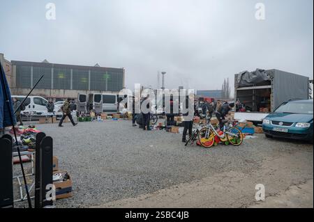 Hunedoara, Rumänien - 25. Januar 2025: Menschenmenge und verschiedene Gegenstände, Spielzeug, Werkzeuge und Elektronik auf einem Flohmarkt. Stockfoto