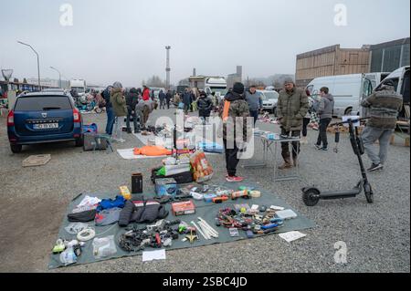 Hunedoara, Rumänien - 25. Januar 2025: Menschenmenge und verschiedene Gegenstände, Spielzeug, Werkzeuge und Elektronik auf einem Flohmarkt. Stockfoto