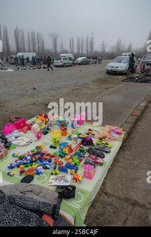 Hunedoara, Rumänien - 25. Januar 2025: Menschenmenge und verschiedene Gegenstände, Spielzeug, Werkzeuge und Elektronik auf einem Flohmarkt. Stockfoto