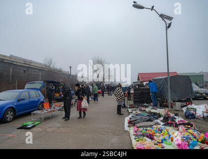 Hunedoara, Rumänien - 25. Januar 2025: Menschenmenge und verschiedene Gegenstände, Spielzeug, Werkzeuge und Elektronik auf einem Flohmarkt. Stockfoto