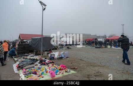 Hunedoara, Rumänien - 25. Januar 2025: Menschenmenge und verschiedene Gegenstände, Spielzeug, Werkzeuge und Elektronik auf einem Flohmarkt. Stockfoto