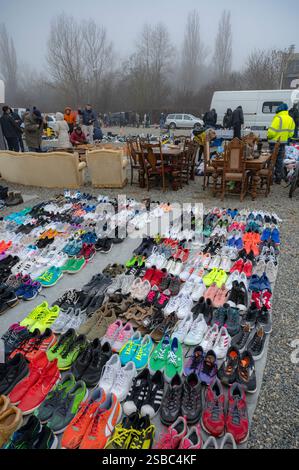 Hunedoara, Rumänien - 25. Januar 2025: Menschenmenge und verschiedene Gegenstände, Spielzeug, Werkzeuge und Elektronik auf einem Flohmarkt. Stockfoto