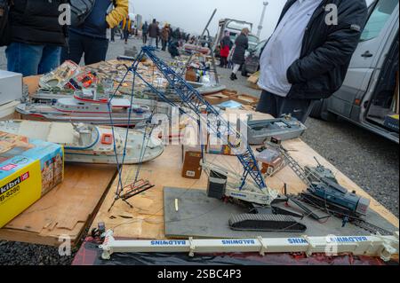 Hunedoara, Rumänien - 25. Januar 2025: Menschenmenge und verschiedene Gegenstände, Spielzeug, Werkzeuge und Elektronik auf einem Flohmarkt. Stockfoto
