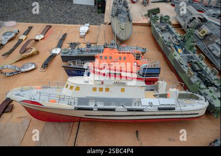 Hunedoara, Rumänien - 25. Januar 2025: Menschenmenge und verschiedene Gegenstände, Spielzeug, Werkzeuge und Elektronik auf einem Flohmarkt. Stockfoto