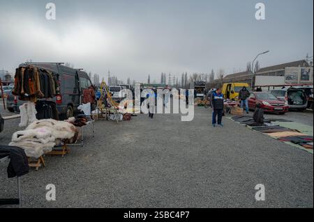 Hunedoara, Rumänien - 25. Januar 2025: Menschenmenge und verschiedene Gegenstände, Spielzeug, Werkzeuge und Elektronik auf einem Flohmarkt. Stockfoto