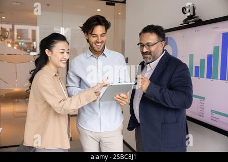 Fröhliche Kollegen, die sich die Online-Projektpräsentation auf einem Tablet ansehen Stockfoto