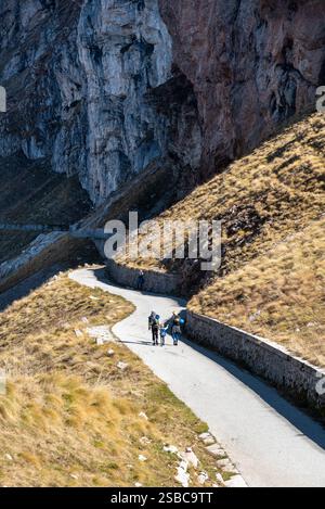 Wanderer, die auf einer Bergstraße in der Nähe einer steilen Klippe in den slowenischen alpen spazieren. Mount Mangart, Slowenien Stockfoto