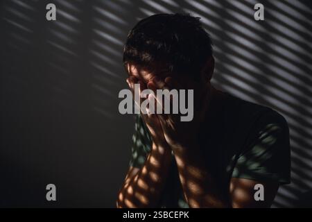 Monatskonzept zur Bewusstseinsbildung der psychischen Gesundheit, niedriges Bild des erwachsenen Mannes, der im dunklen Raum weint, selektiver Fokus Stockfoto