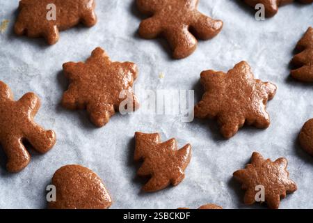 Frisch gebackene, hausgemachte Lebkuchenweihnachtskekse auf Pergamentpapier Stockfoto
