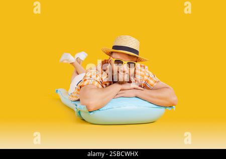 Glücklicher Mann, Der Sich Auf Einer Aufblasbaren Matratze Auf Orangefarbenem Hintergrund Entspannt Stockfoto