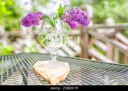 Blumenstrauß-Anordnung in Glasvase mit Wasser draußen auf dem Tisch bei der Gartenterrasse des Hauses Stockfoto