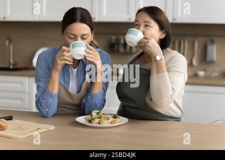Familie trinkt Tee am Morgen, isst Sandwiches in der Küche Stockfoto